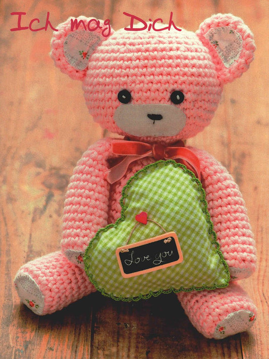 Liebeskarte niedlicher gehäkelter rosa Teddybär mit grünem Herz und Love you Botschaft perfekte Postkarte für Verliebte und romantische Grüße