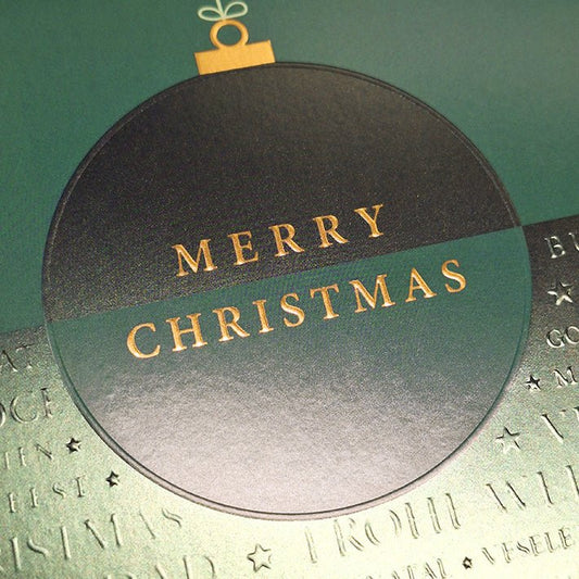 Weihnachtskarte mit eleganter grüner Christbaumkugel und festlichem Schriftzug