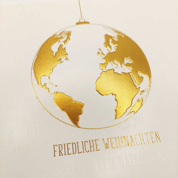 Weihnachtskarte mit goldener Weltkugel und festlichem Schriftzug in warmem Glanz