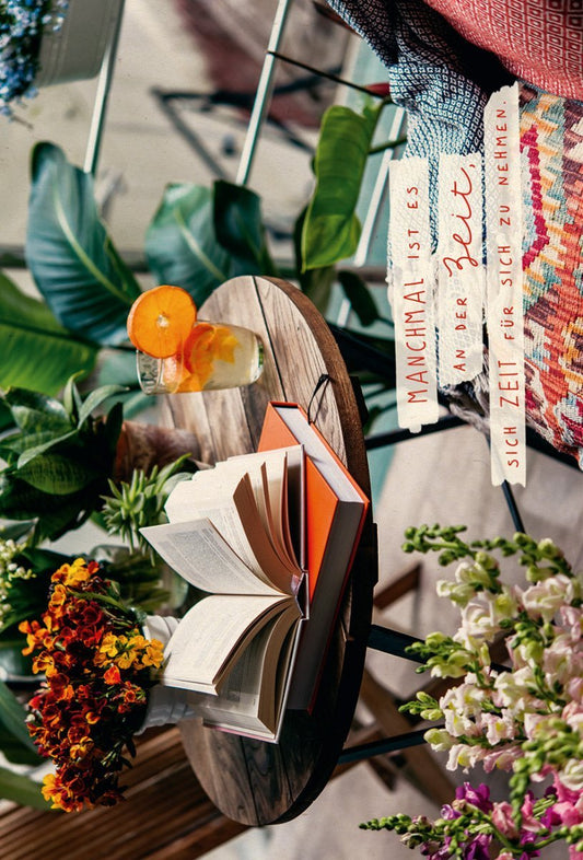 Lebensweisheiten - Postkarte: Zeit genießen mit Bücher und Blumen auf Holztisch, Zuckerrohrpapier
