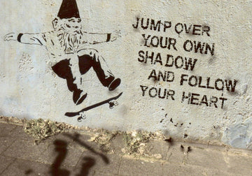 Postkarte – Englische Spruchkarte mit Streetart Zwerg auf Skateboard und Herz - Schatten Motiv – Folge Deinem Herzen