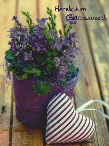 Postkarte lila Blumen im Topf mit Stoffherz und Aufschrift Herzlichen Glückwunsch liebevolle Postkarte zur Gratulation
