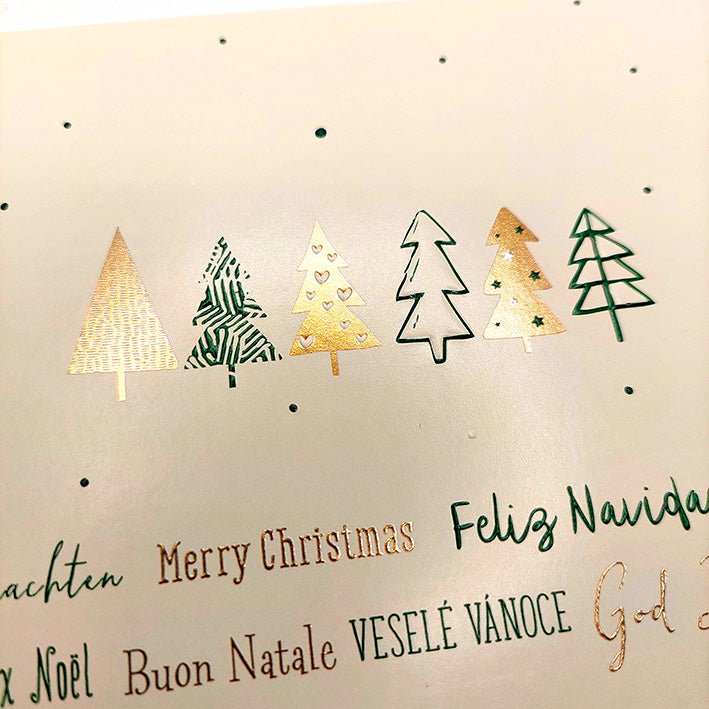 Weihnachtskarte mit festlichen Tannenbäumen in gold - grüner Winterpracht