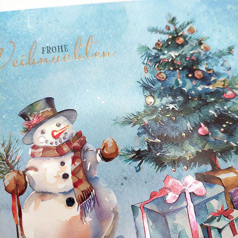 Weihnachtskarte mit fröhlichem Schneemann und festlich geschmücktem Tannenbaum