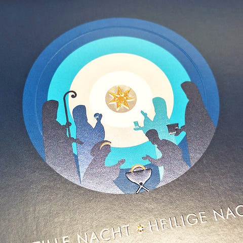 Weihnachtskarte mit stimmungsvollem Krippenspiel und leuchtendem Sternenhimmel