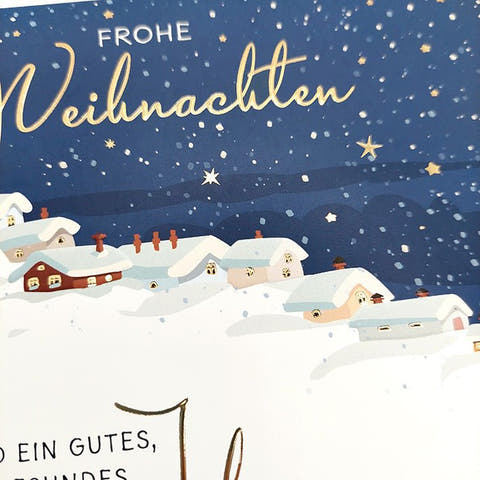 Weihnachtskarte mit verschneitem Dorf und funkelnden Sternen im Wintertraum
