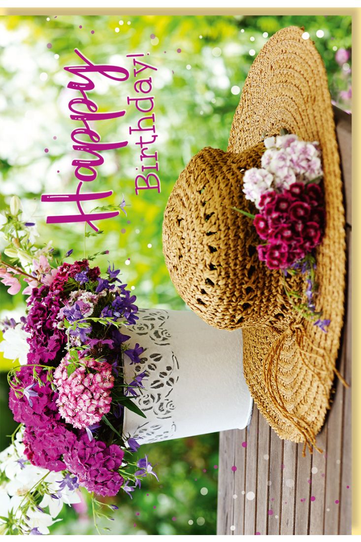 Geburtstagskarte mit sommerlichem Blumenarrangement und Strohhut auf Holztisch