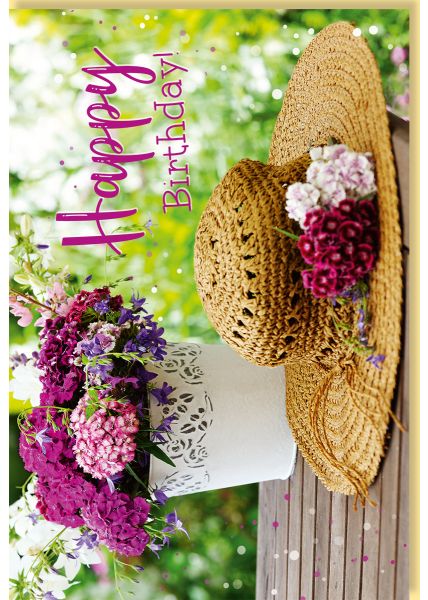 Geburtstagskarte mit sommerlichem Blumenarrangement und Strohhut auf Holztisch